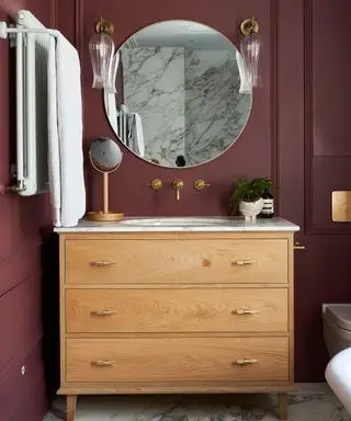 Idées de miroir de salle de bain avec miroir rond et mur rouge