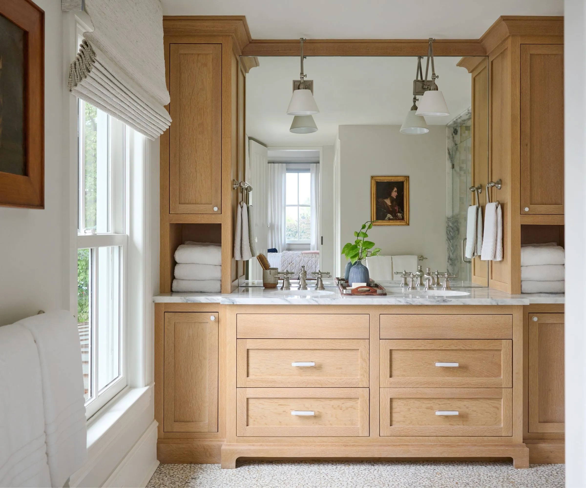 חדר רחצה לבן עם כיור אמבטיה מעץ ויחידות אחסון מסביב' loading='lazy' title=