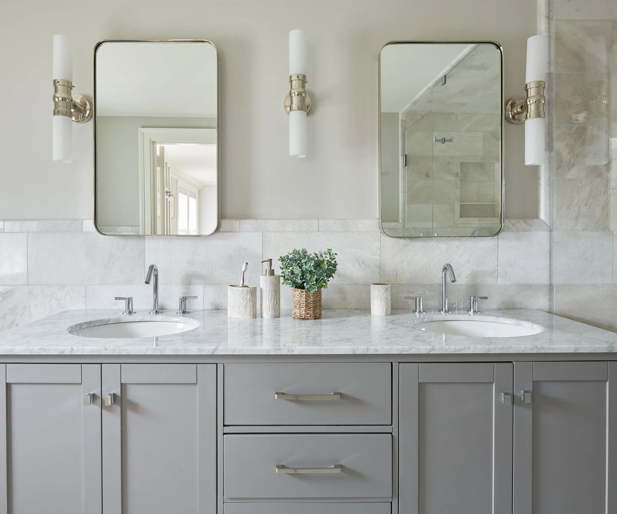 חדר רחצה ניטרלי עם כיור אפור וסירים אסתטיים לאחסון מברשות שיניים' loading='lazy' title=