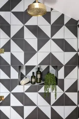 Ducha en blanco y negro con estante empotrado.