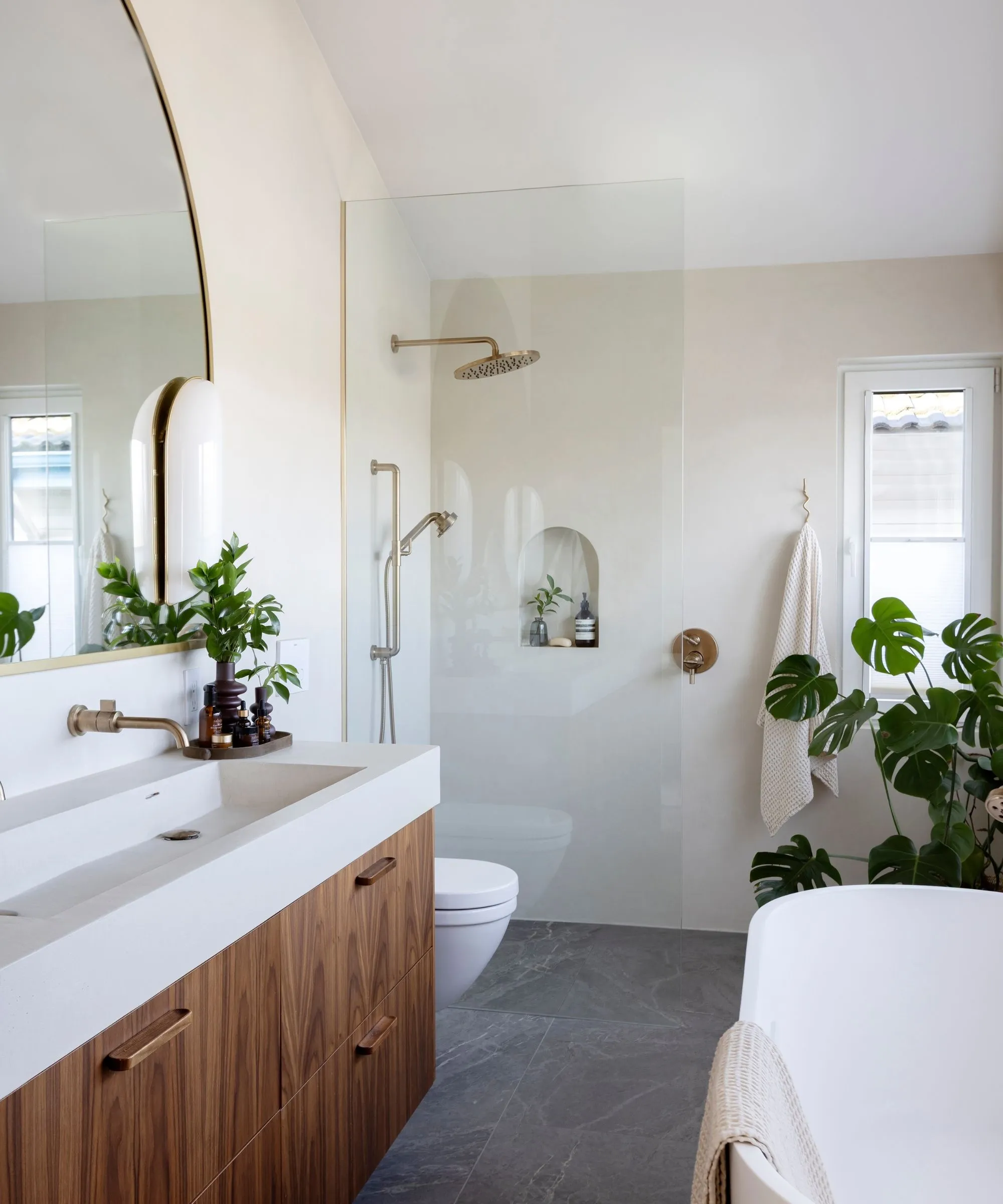 חדר אמבטיה נייטרלי עם קירות לבנים חמים מסך מקלחת זכוכית יהירות עץ ודלפק מיקרו וכיור' loading='lazy' title=