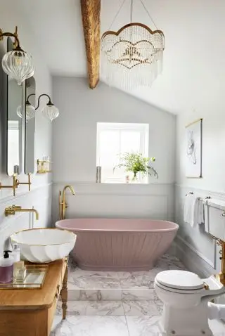 Une petite salle de bain avec un sol en marbre et une baignoire rose au design nervuré vertical