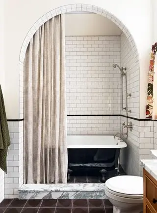 Petite salle de bain avec encadrement de porte cintrée et carrelage métro blanc