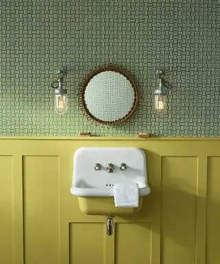 Un gros plan d'un petit lavabo jaune et blanc dans une salle de bains