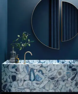 Un exemple d'idées de couleurs de salle de bain montrant un lavabo de salle de bain en marbre bleu et une double vasque
