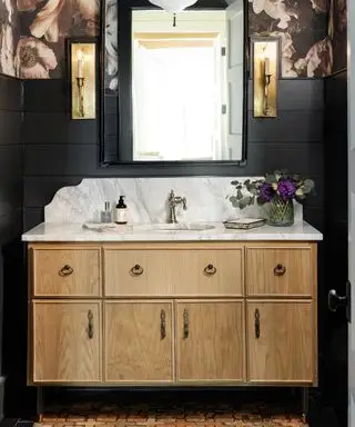 idées de salle de bain noire, salle de bain noire avec papier peint à fleurs au-dessus de rainures et languettes noires, meuble vasque en bois et marbre, miroir, carrelage style terre cuite