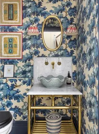 Salle d'eau avec papier peint bleu et accessoires dorés
