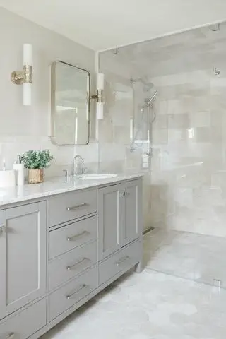 グレーの洗面化粧台を備えたタイル張りのバスルーム