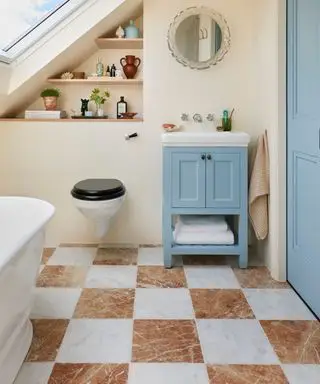 Sol de salle de bains en marbre rouge orange et damier blanc avec un petit lavabo et un miroir vintage