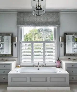 Salle de bains de luxe avec éclairage, murs gris et miroirs