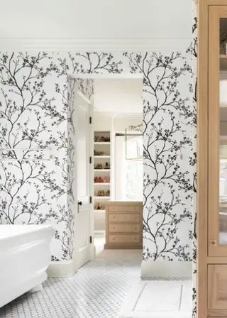 Salle de bains de ferme avec papier peint floral noir et blanc et éléments en bois
