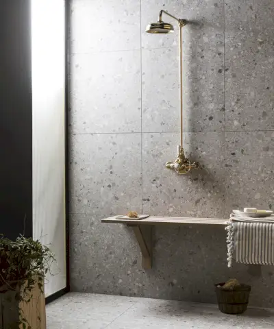 Una stanza umida grigia con faretto e sanitari bianchi.