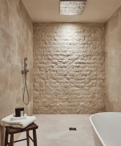 Piccole idee per una stanza umida illustrate in un bagno piastrellato a spina di pesce grigio.