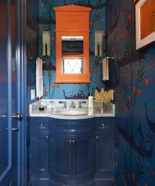 idées de salle de bains étroites, salle de bains bleue et orange avec des accents orange, papier peint bleu et orange