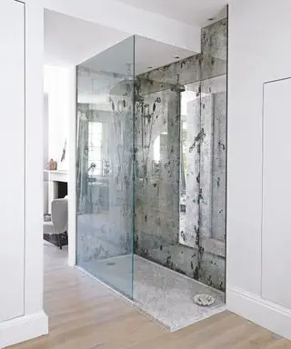 Otevřený sprchový kout se skleněnou zadní stěnou a zrcadlovými stěnami.