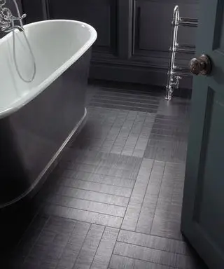 흰색과 회색 욕조가 있는 욕실의 검정색 비닐 바닥, 검정색 페인트 벽