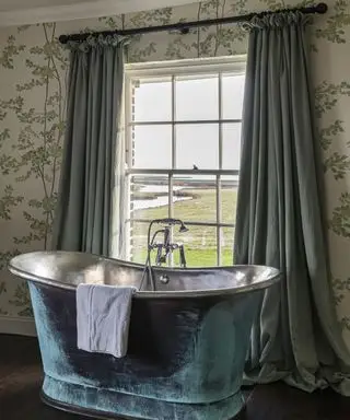 Idées de rideaux de salle de bain avec de longs rideaux verts, assortis à une baignoire en métal vert