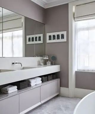Un exemple de conception d'une salle de bain montrant une salle de bain grise moderne avec un meuble double vasque sous un grand miroir mural