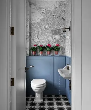 Un bagno con WC e copertura per cisterna incorporata, sulla quale è presente una mensola con fiori rosa