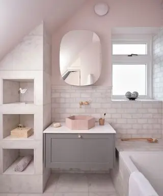 Bagno rosa e in marmo con pareti e pavimenti in marmo, vasca, zona lavandino e scaffali su misura con ripiani incassati, esclusivo lavabo esagonale rosa