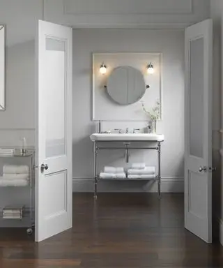 Un esempio di idee per mensole da bagno che mostrano un bagno con un mobile lavabo aperto con una mensola in metallo sotto il lavandino