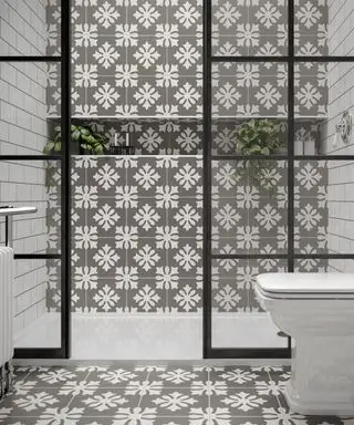 Une cabine de douche avec des carreaux à motifs gris.