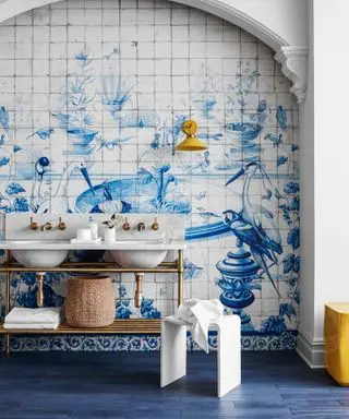 Une salle de bains au thème bleu avec des carreaux peints en bleu et blanc avec des oiseaux et des fontaines d'eau