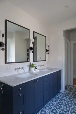 salle de bain bleu marine avec meubles bleus, double miroir et carrelage à motifs