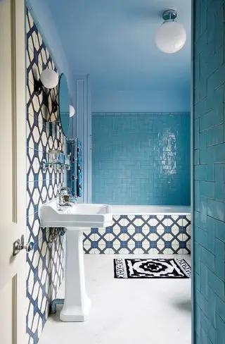 Baño con azulejos azules y blancos.