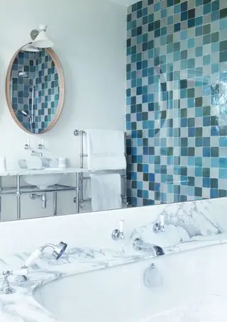 Baño azul y blanco con cerramiento de azulejos.