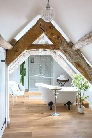 コテージのバスルームのアイデア 自立型バスと梁を備えたロフトエクステンションのアリッジハウスバスルーム