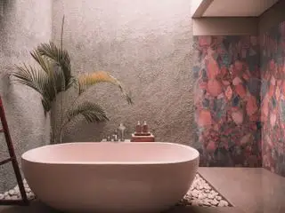 Une salle de bains spa extérieure avec une baignoire blush et un mur en marbre aux nuances roses, rouges et grises