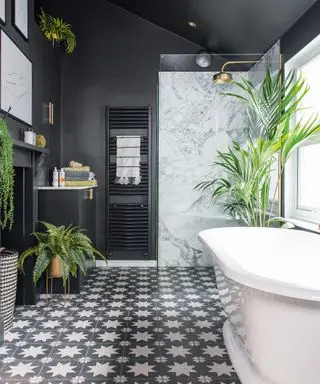 Baño negro con suelo estampado y plantas.