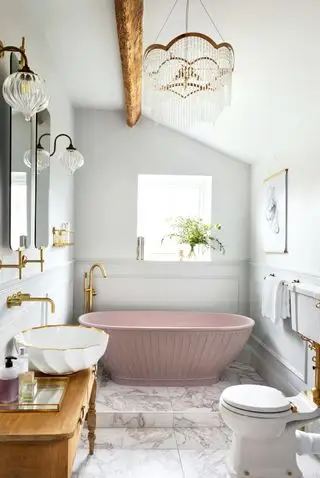 idées de salle de bains traditionnelles - baignoire rose dans une salle de bains traditionnelle avec carrelage en marbre et vaisselle blanche