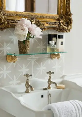lavabo de salle de bain avec miroir antique et verre antique de fleurs