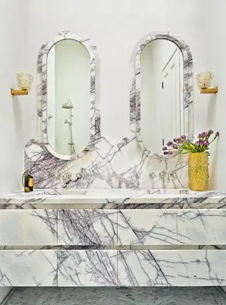 Salle de bain en marbre avec miroirs incurvés et vanité
