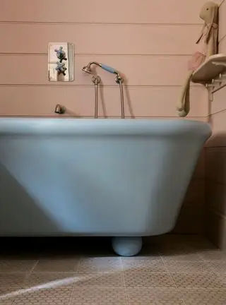 Salle de bain bleue avec murs beiges et baignoire bleue