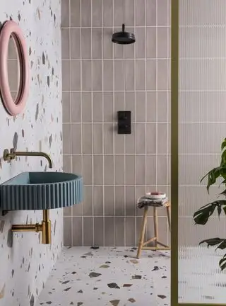Salle de bain en terrazzo avec carrelage rose et vasque bleue