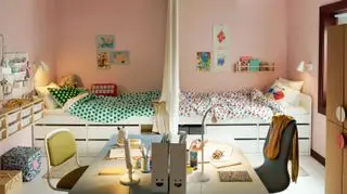 Ideen für ein gemeinsames Kinderzimmer in Rosa mit symmetrischen weißen Betten, Schubladen und Schreibtischbereichen sowie farbenfroher Bettwäsche und Accessoires.