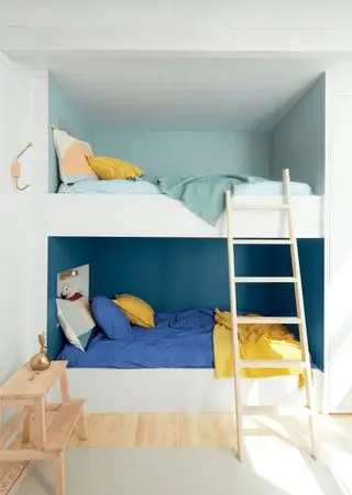 Weiße, in die Wand eingebaute Etagenbetten mit passender Wandfarbe für jedes Bett
