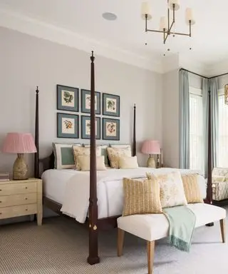 Kremfarget soverom med himmelseng og kunst over sengen