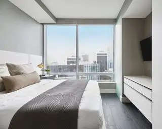 Une idée TV dans une chambre avec une télévision dans l'alcôve entre les armoires, dans une chambre d'appartement moderne avec vue sur la ville