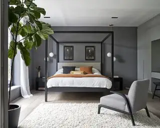 Une chambre aux murs gris foncé et un lit à baldaquin noir et contemporain