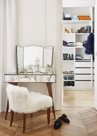 Coiffeuse vénitienne et miroir en premier plan et dressing en arrière-plan, sol à chevrons