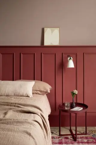 chambre rouge avec lambris peints en rouge, mur supérieur rose, literie en lin rose, chevet rouge, applique murale