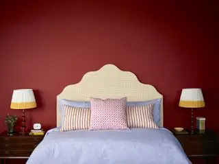 chambre rouge avec lampes de chevet assorties, tête de lit et coussins à motifs