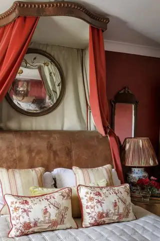chambre aux murs rouges, baldaquin en tissu rouge, lit en cuir
