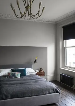 chambre grise et blanche avec murs gris bicolores, parquet foncé, tête de lit peinte de manière abstraite gris foncé, applique murale