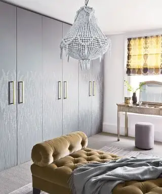 壁紙張りのワードローブとビーズのシャンデリアを備えたドレッシング ルーム