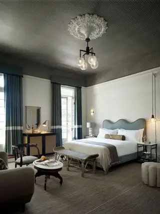 spálňa so sivým vzorovaným stropom a šedomodrou posteľou